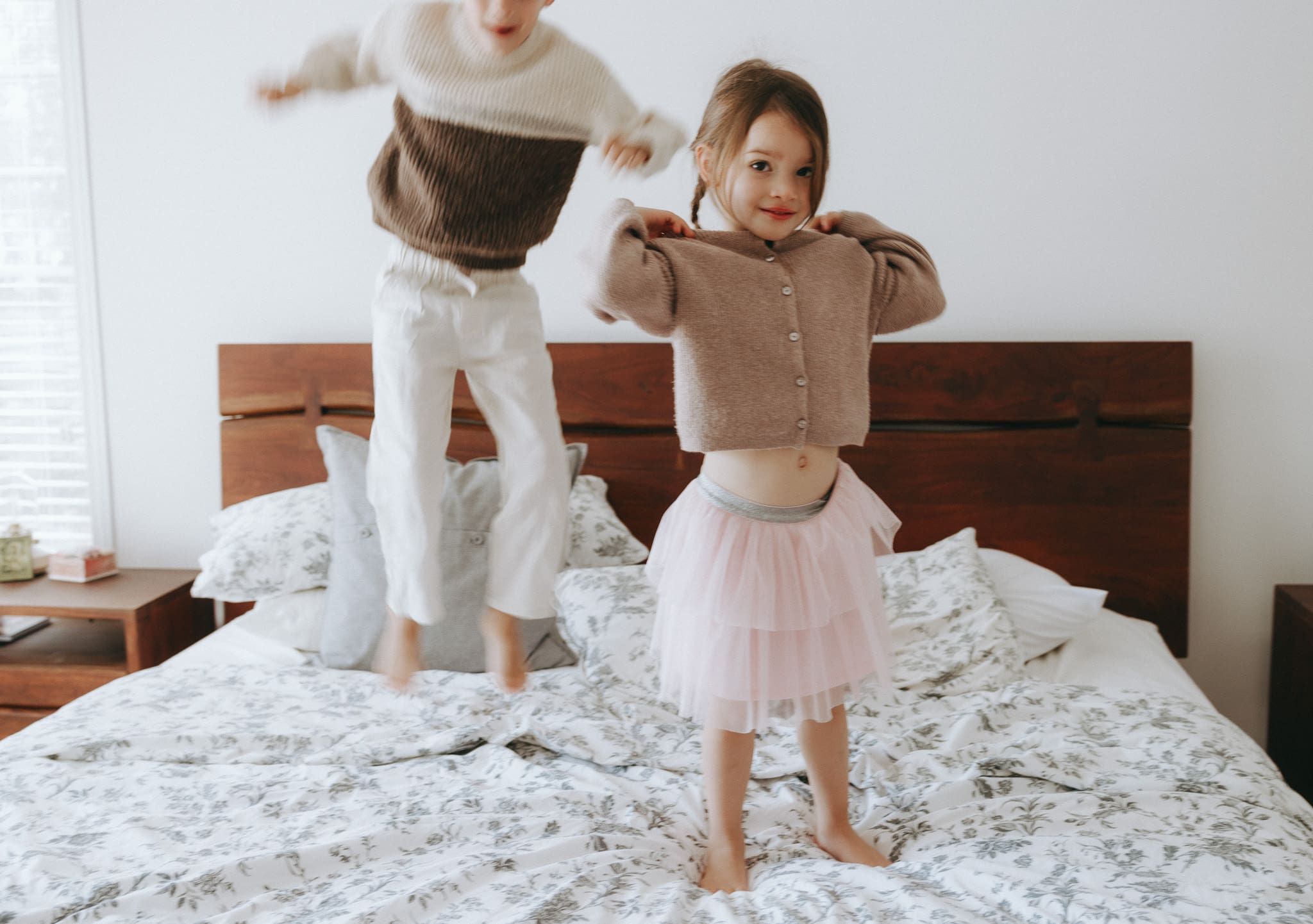 Lifestyle family photography in Montreal capturing kids jumping on the bed during an in home session