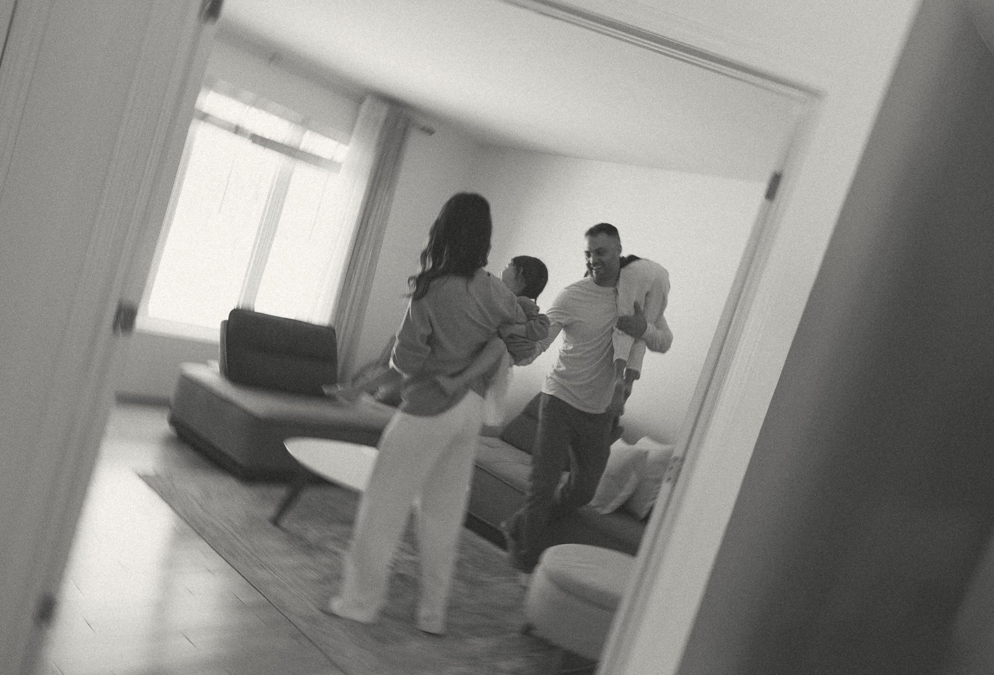 family running around the living room for a candid family session