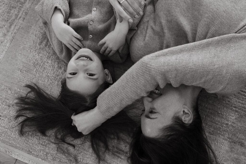 Mother and daughter cuddling and laughing for an artful family portrait