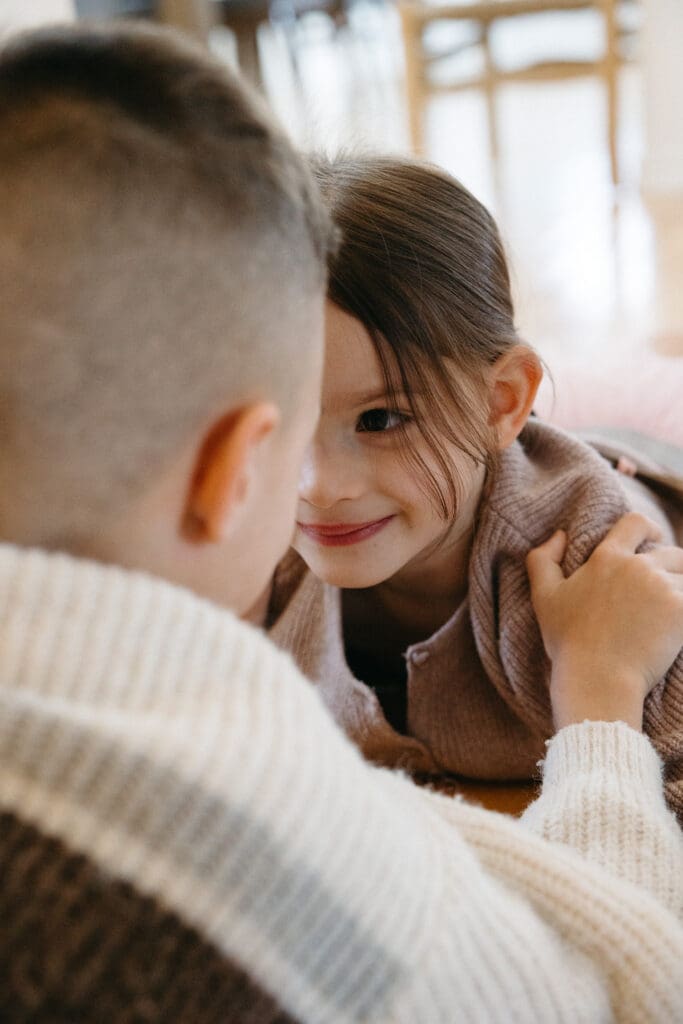 Siblings playing with each other for a in-home family photoshoot in Montreal