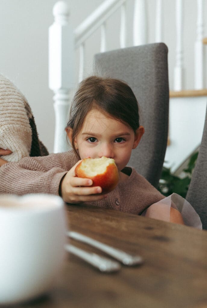 girl eating apple for a candid family photoshoot in Montreal