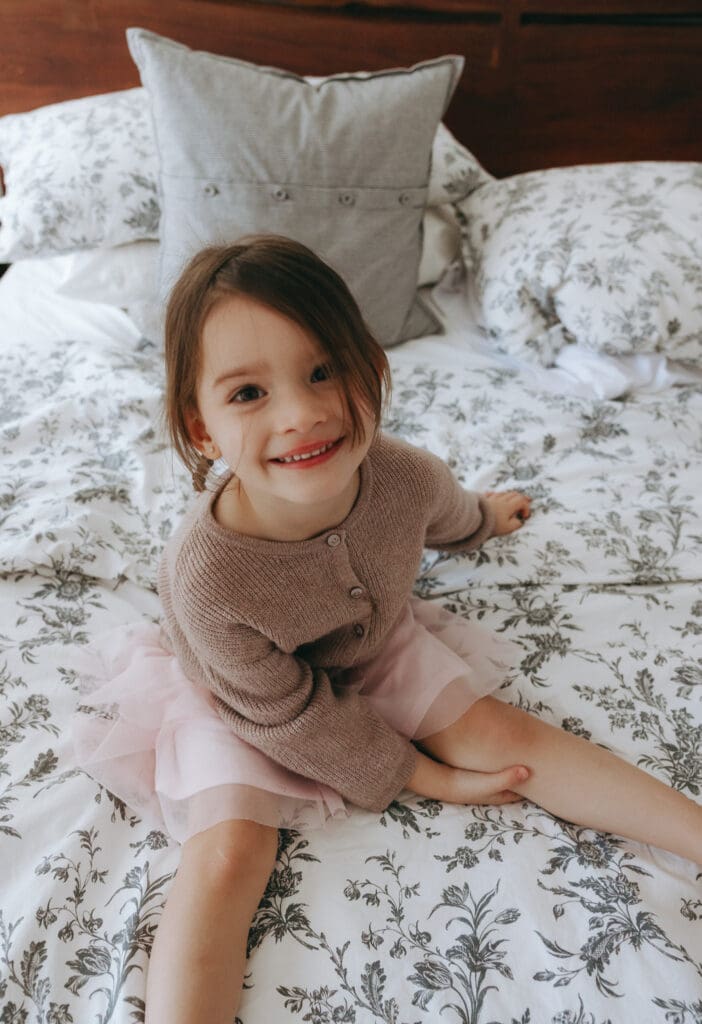 girl smiling on the bed during a family photoshoot