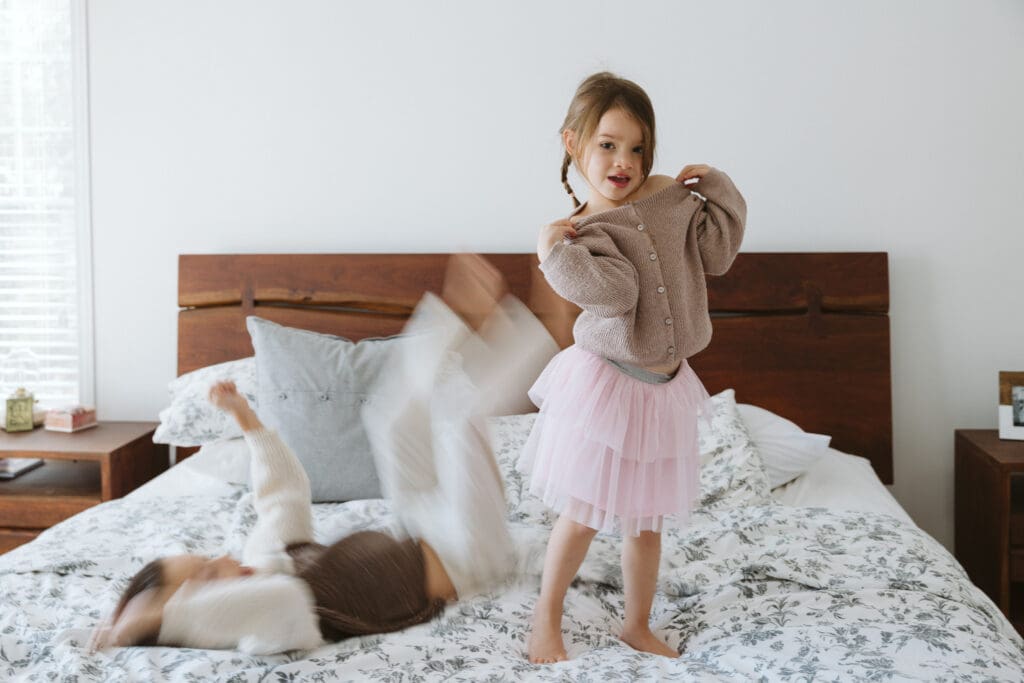 kids jumping on the bed for a lifestyle family session
