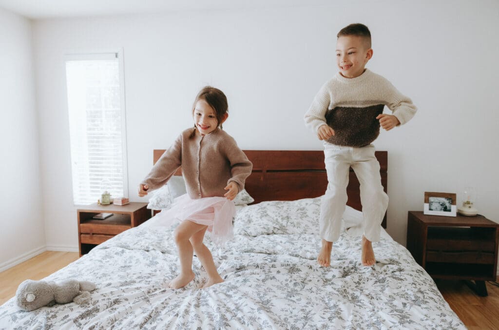 children jumping on the bed during a storytelling family session in Montreal