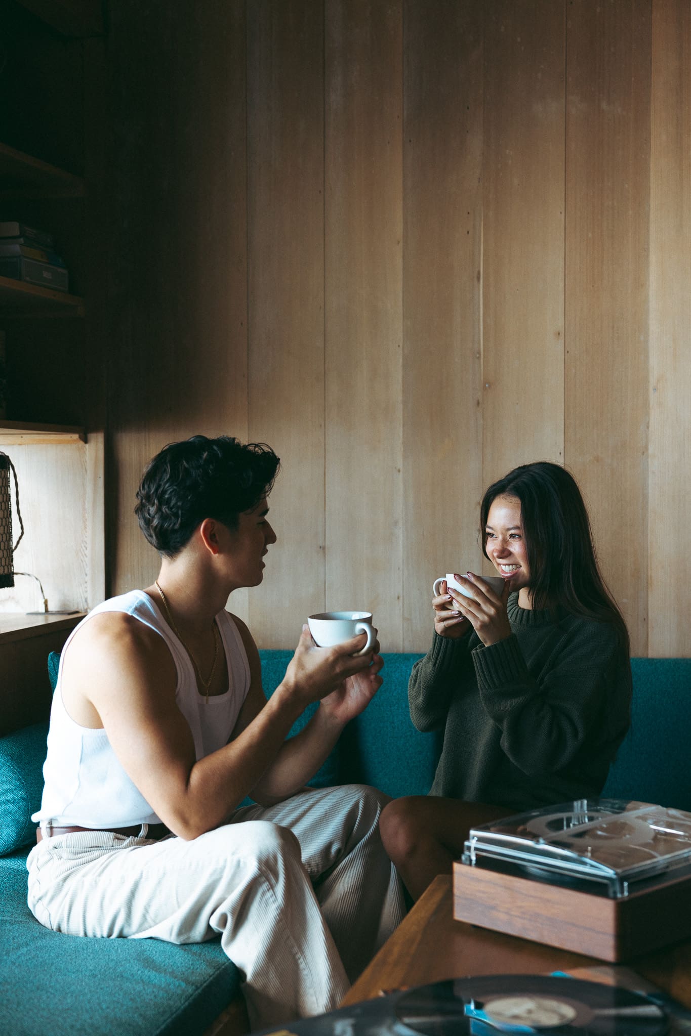 a couple smiling and drinking coffee at the cottage for a couples photoshoot 