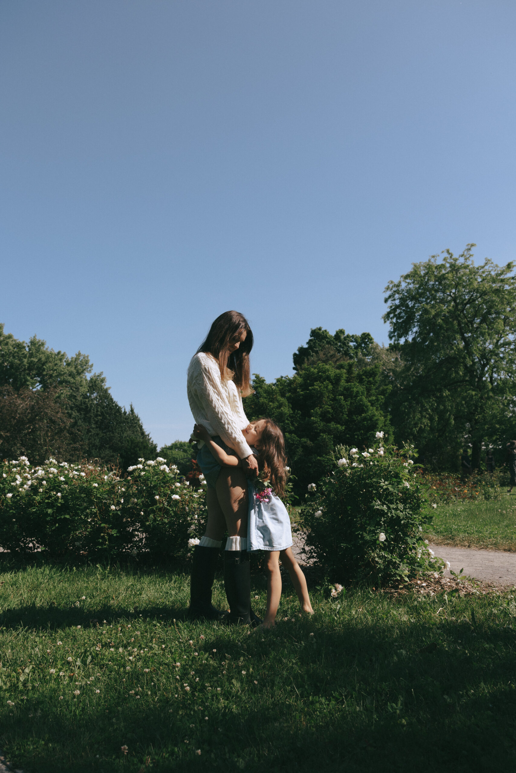 Mom and daughter hugging for a family session in a park in Montreal
