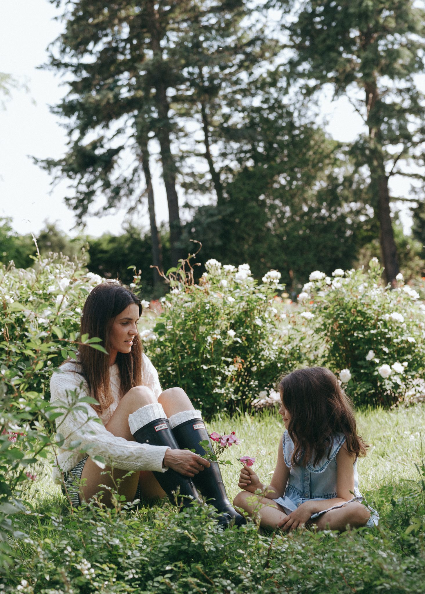 family photoshoot at the Montreal botanical garden. Mom and daughter picking flowers.