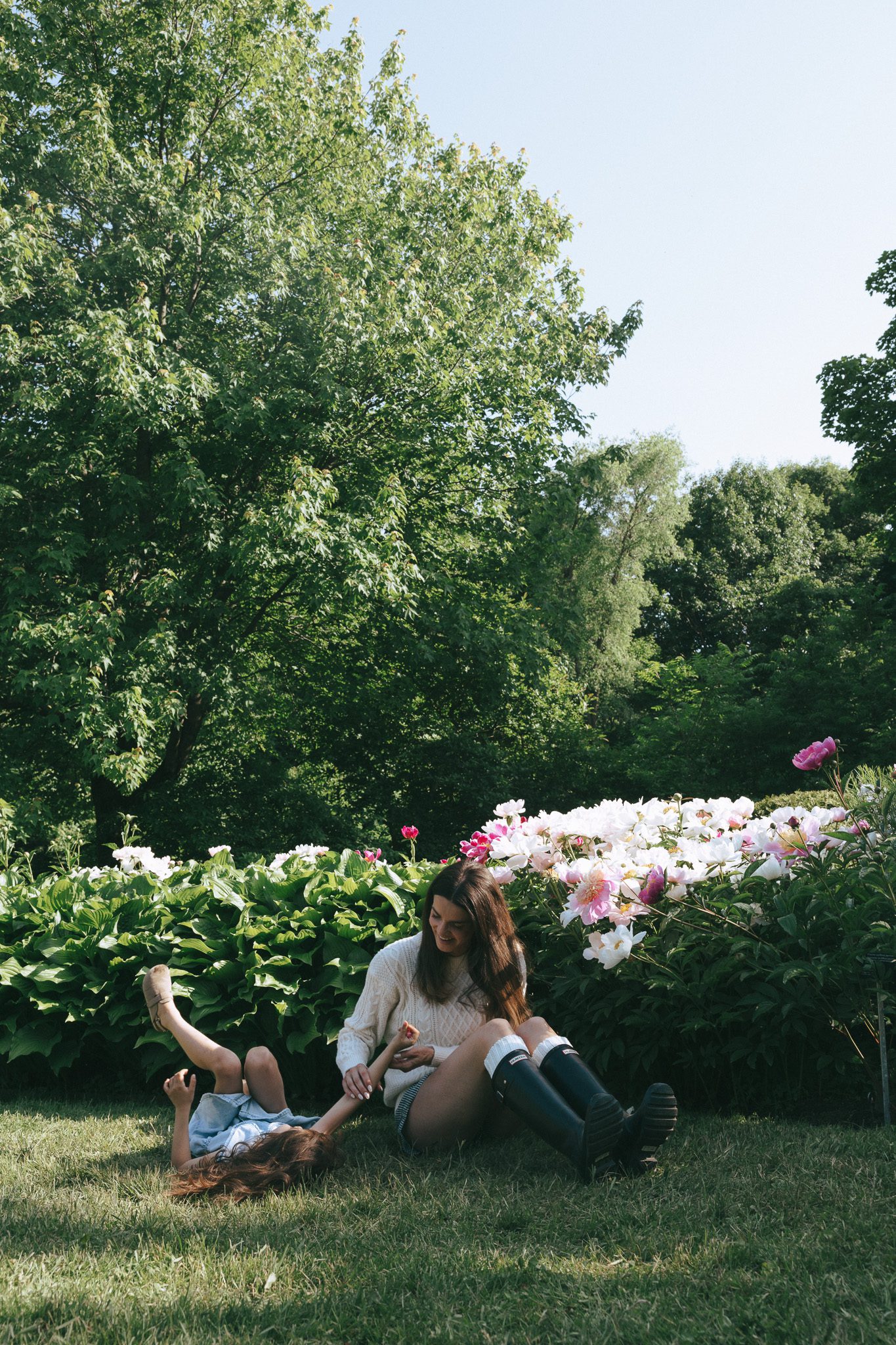 mom and daughter playing and tickling in the flower garden for a family session