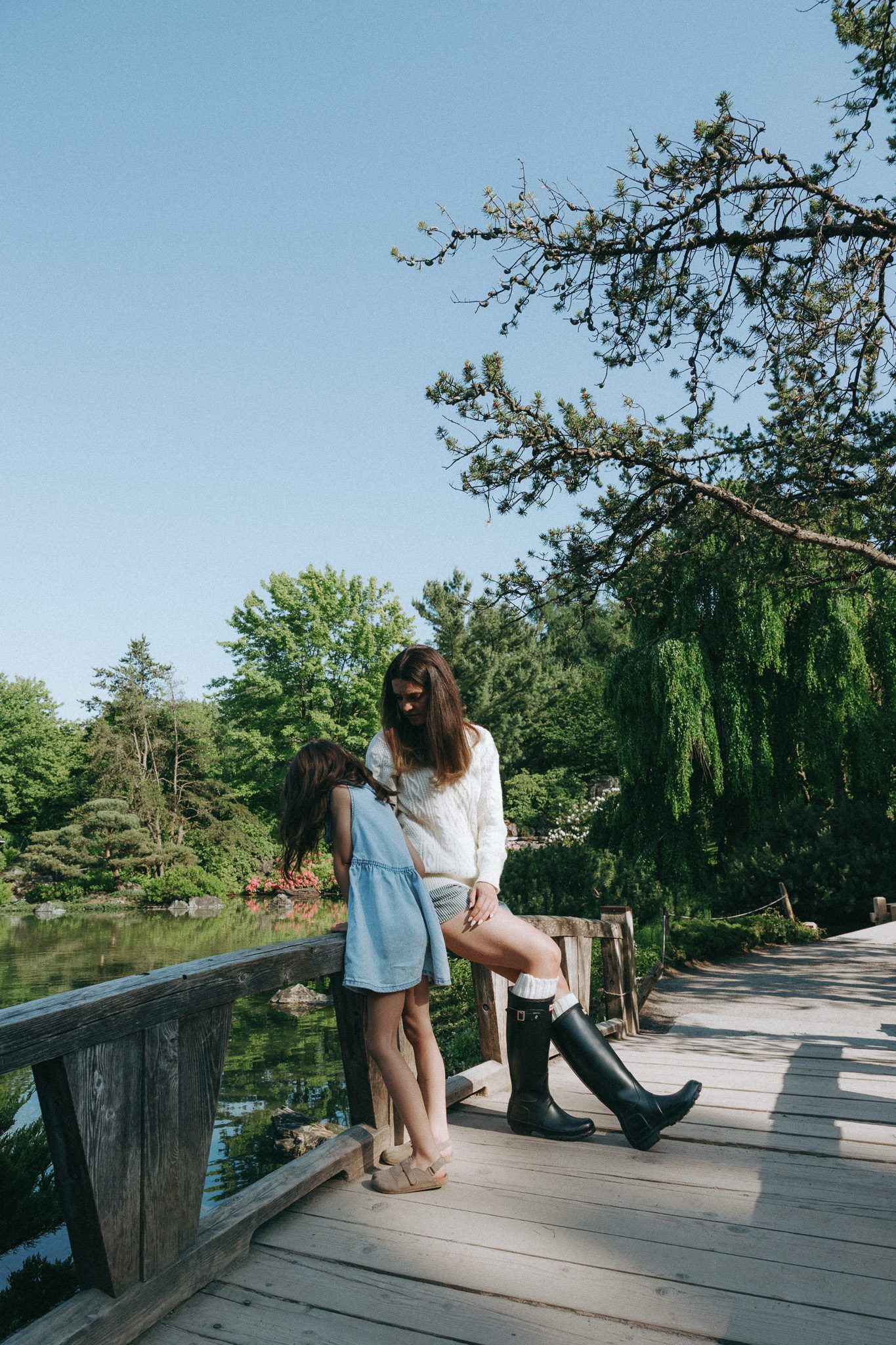 Mom and daughter on the bridge looking into the water at the Jardin botanique de Montréal