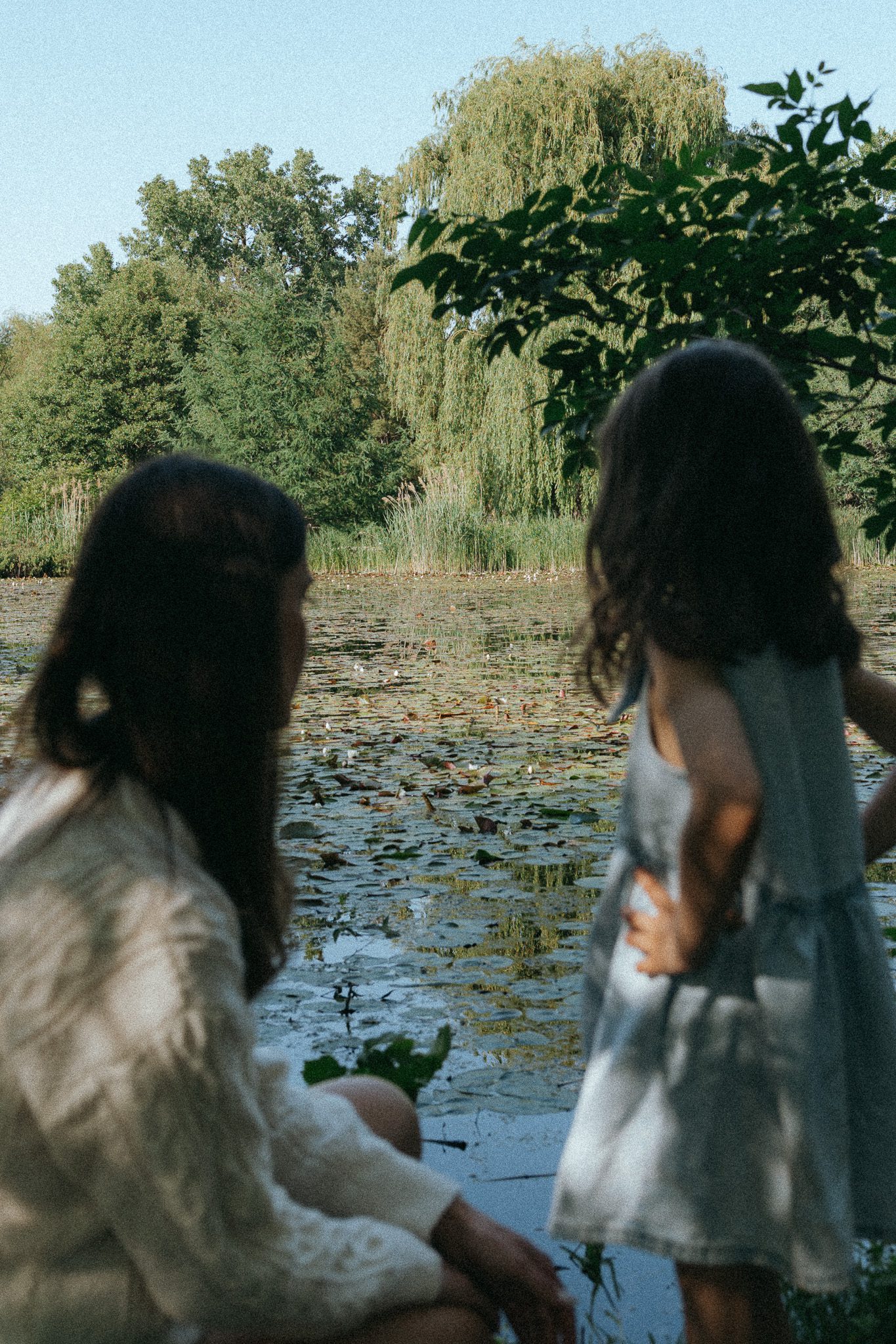 Mom and daughter looking out towards the pond, for a photoshoot at the Jardin botanique de Montréal.