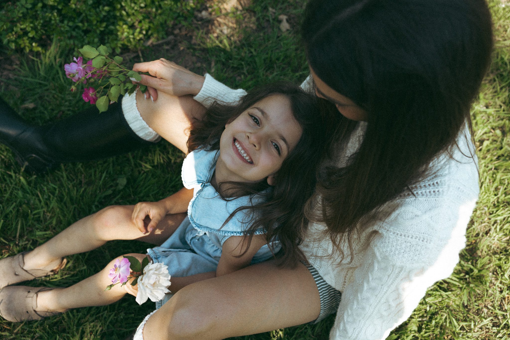 Child in her mothers arms, smiling for a family photoshoot at Jardin botanique de Montréal