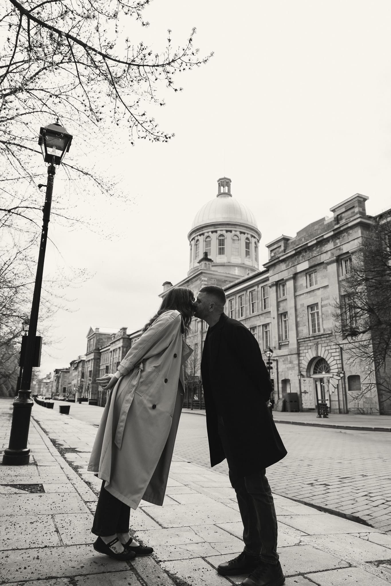 A couple kissing in front of the Marche Bonsecours for a session