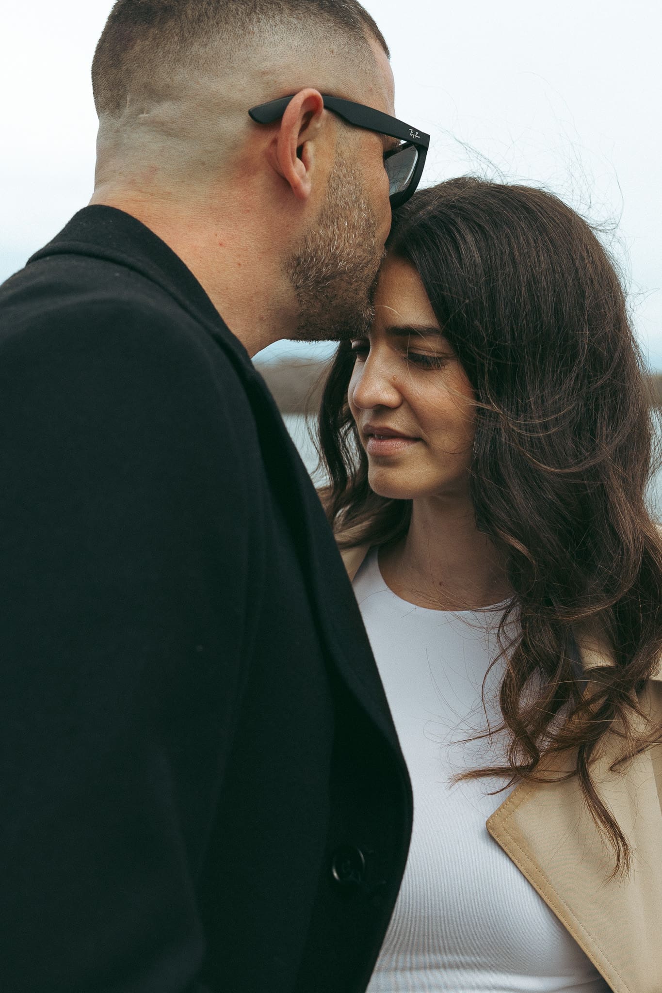 A man kissing his wife on the forehead downtown Montreal for a couples photoshoot