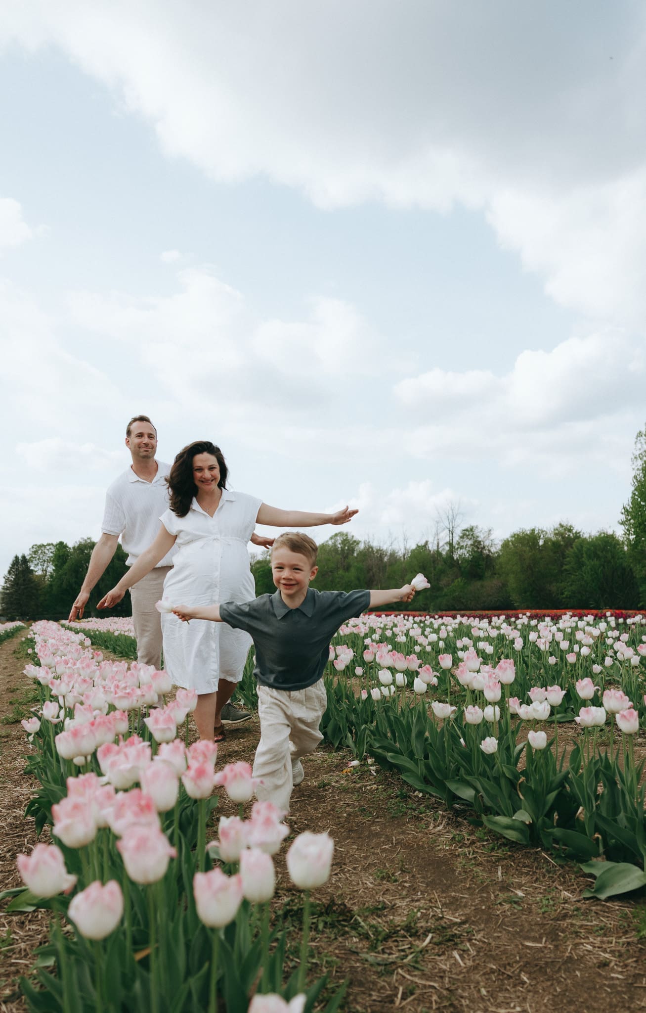 Family walking through tulip fields during a family photography session in Montreal